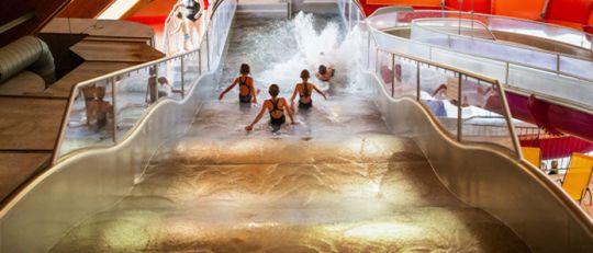 Kinder rutschen auf einer breiten Wellenrutsche