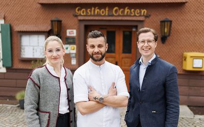 Trois personnes se tiennent devant l'hôtel-boutique Ochsen