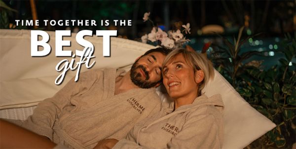 A man and a woman lie in a shell at Therme Euskirchen, inscription ‘Give the gift of time together’