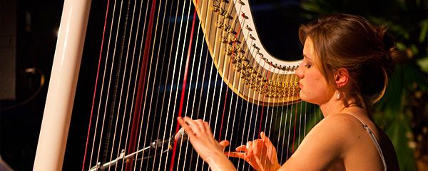 Musikerin an einer Harfe