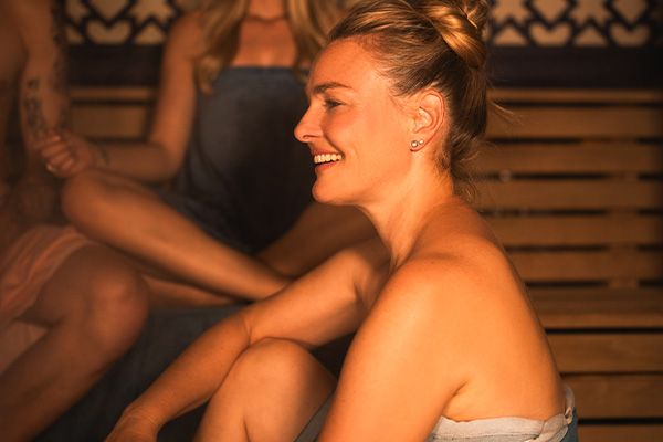 Frau in einer Saiuna lächelt entspannt