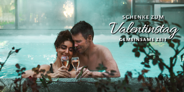 Frau und Mann mit Sektgläsern im Außenpool und Schrift mit "Schenke zum Valentinstag gemeinsame Zeit"