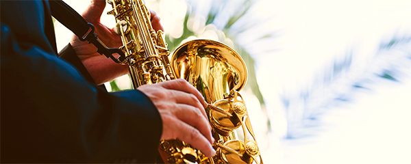 Nahaufnahme mit Händen die ein Saxophon halten