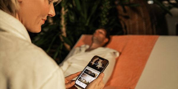 Person hält Smartphone mit geöffneter App.