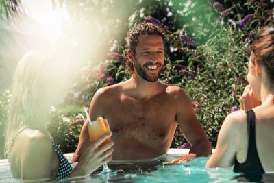 Zwei Frauen und ein Mann unterhalten sich draußen im Wasser