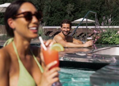 	Frau trinkt einen Cocktail im Pool