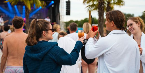 Zwei Personen im Bademantel stoßen mit Cocktails an