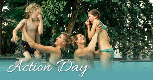 Eltern heben lachend ihre zwei Kinder in die Höhe und spielen in der Blauen Lagune