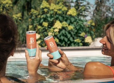 Zwei Frauen sind im Pool mit BLUPHORIA Drinks in der Hand