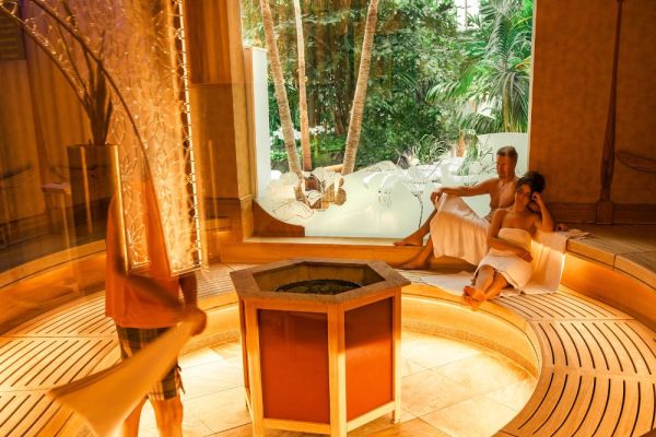 Frau und Mann genießen Aufguss in der Sauna Art Nouveau