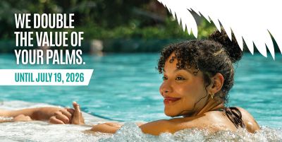 A woman in a swimming pool, with the caption “We’ll double the value of your Palms until 19 July”