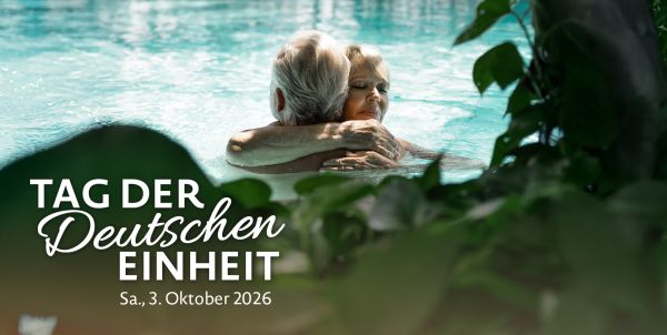 Älteres Paar umarmt sich in der Blauen Lagune, Schriftzug "Tag der deutschen Einheit"