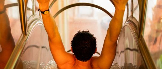 Mann hängt am Start einer sehr steilen Wasserrutsche